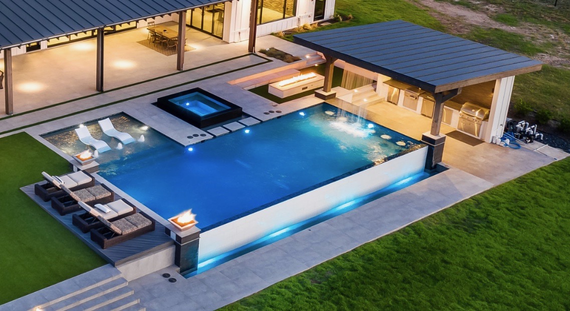 Aerial view of a large pool with spa, fire feature and loungers