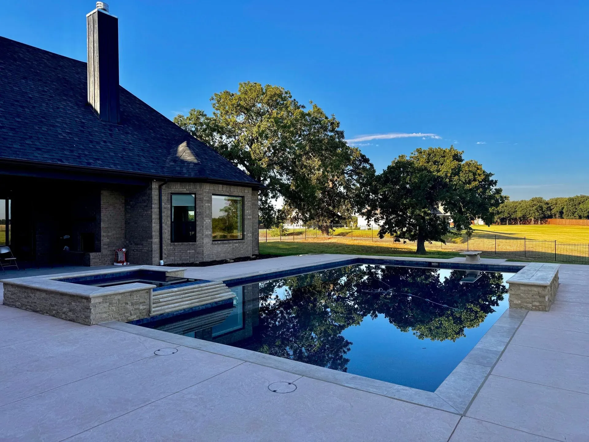Black-bottom pool and spa with a countryside view