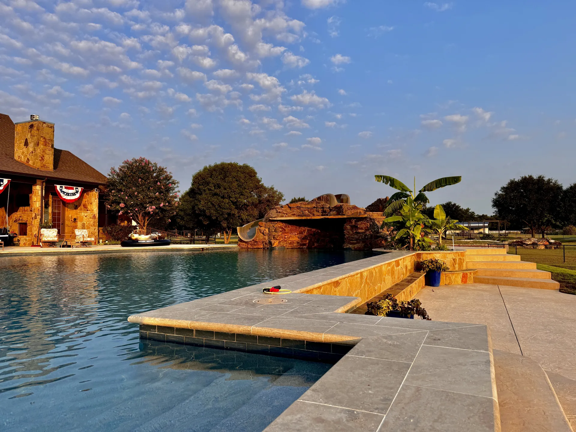 Large pool with a rock grotto and travertine decking